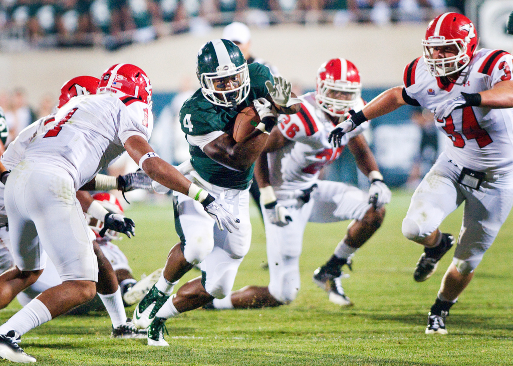 Junior running back Edwin Baker cuts through the Youngstown State defense Friday at Spartan Stadium. Baker ran for 91 yards in the Spartans 28-6 victory over the Penguins. Matt Radick/The State News